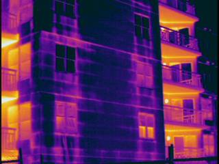 Water damaged EIFS appears warm after sunset; building imaged from exterior
